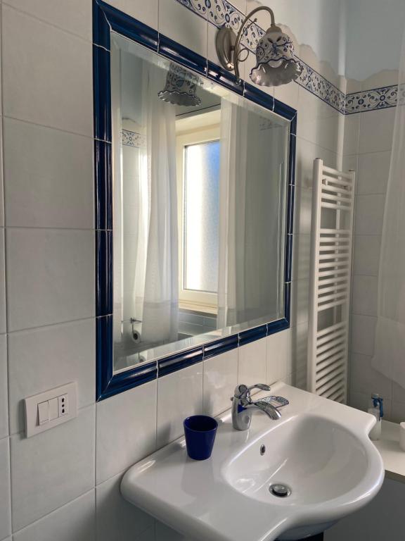 a white bathroom with a sink and a mirror at Casa Blu Cobalto in Maiori