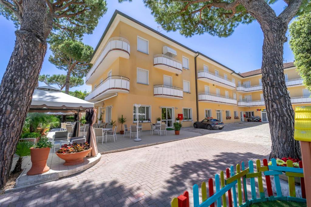 żółty budynek z płotem przed nim w obiekcie Hotel Romagna w mieście Riccione