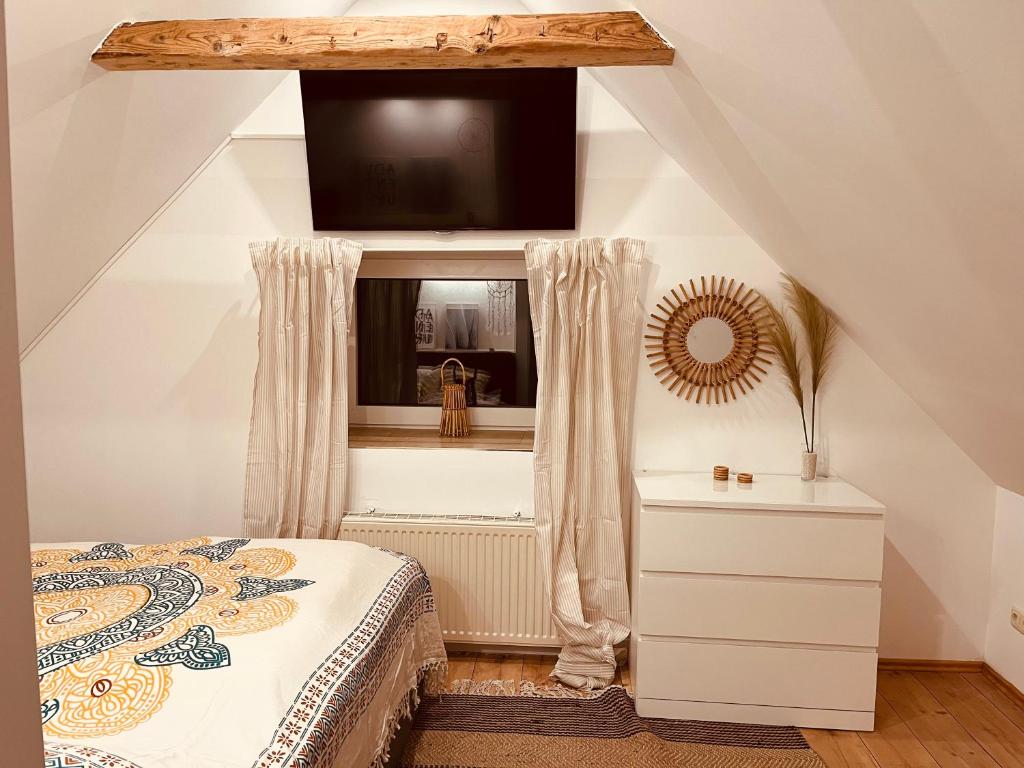 a bedroom with a bed and a window with a television at Deich Winde 9.2 in Dorum Neufeld