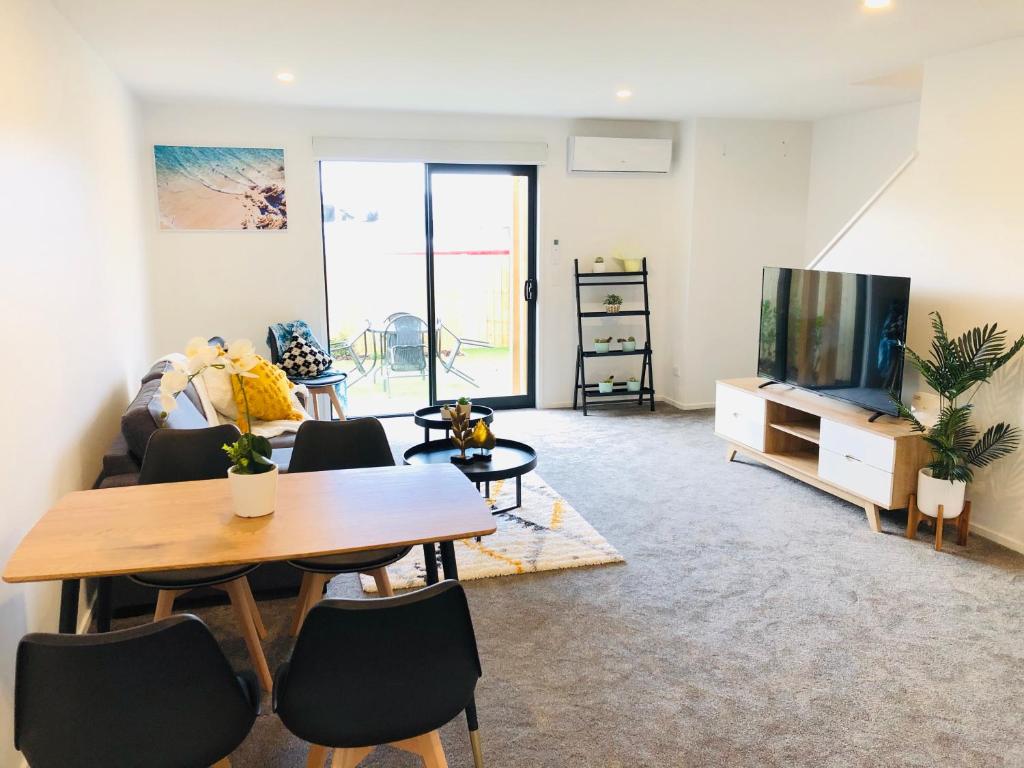 a living room with a table and a tv at Arena,Railway Station Townhouse with Free car park in Christchurch
