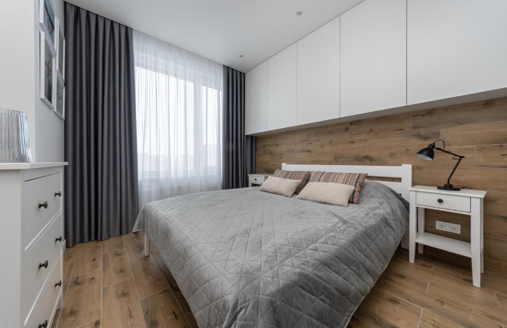 1 dormitorio con 1 cama y pared de madera en MYFREEDOM Апартаменти, Теремки, ВДНГ en Kiev