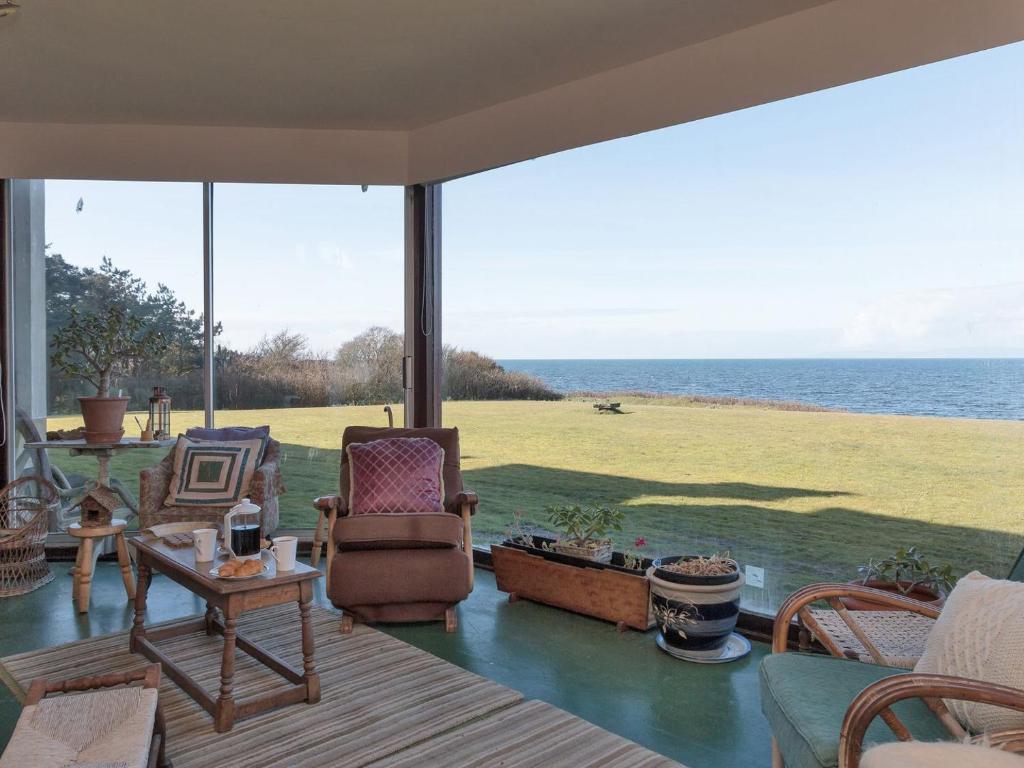a screened in porch with a view of the ocean at Bentfield in Prestwick