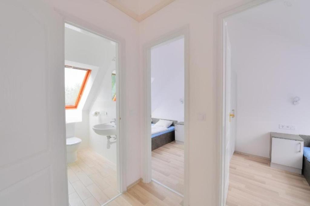 uma casa de banho branca com um lavatório e um WC em Villa Oliver Balatonlelle em Balatonlelle
