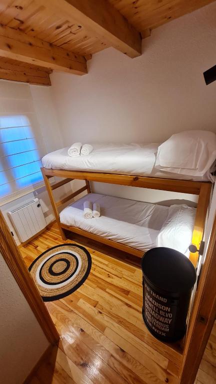 two bunk beds in a room with a wooden floor at Boí Taüll CALMA DÚPLEX in Taull