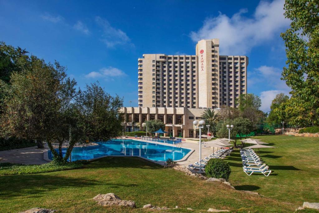 ośrodek z basenem i dużym budynkiem w obiekcie Ramada Jerusalem Hotel w Jerozolimie