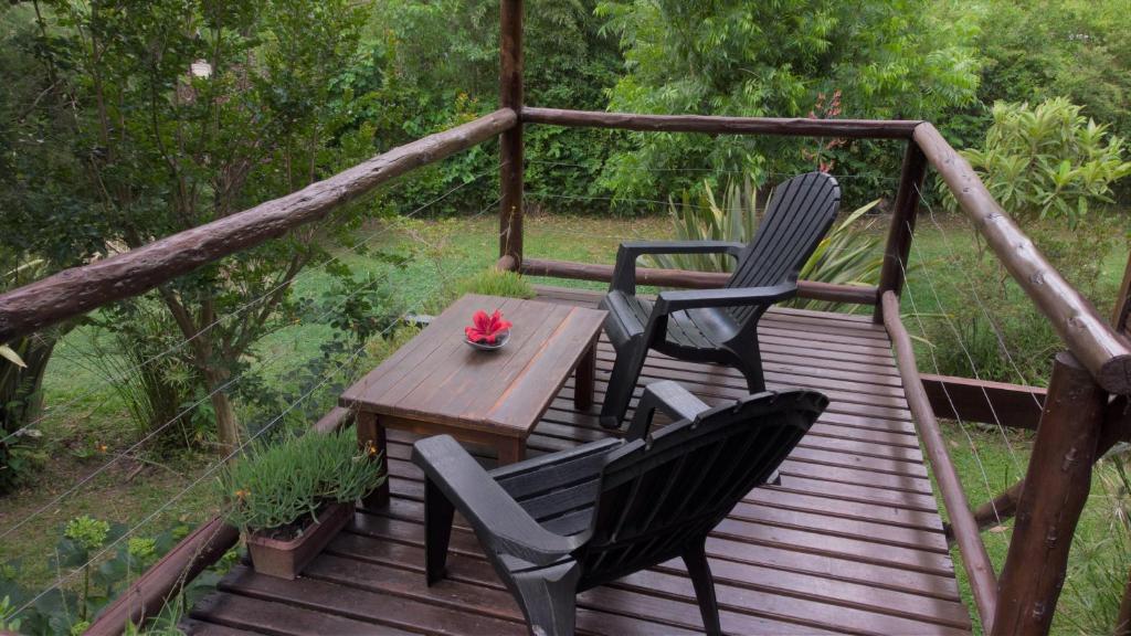 2 sillas y una mesa en una terraza de madera en Cabañas ICh en Tigre