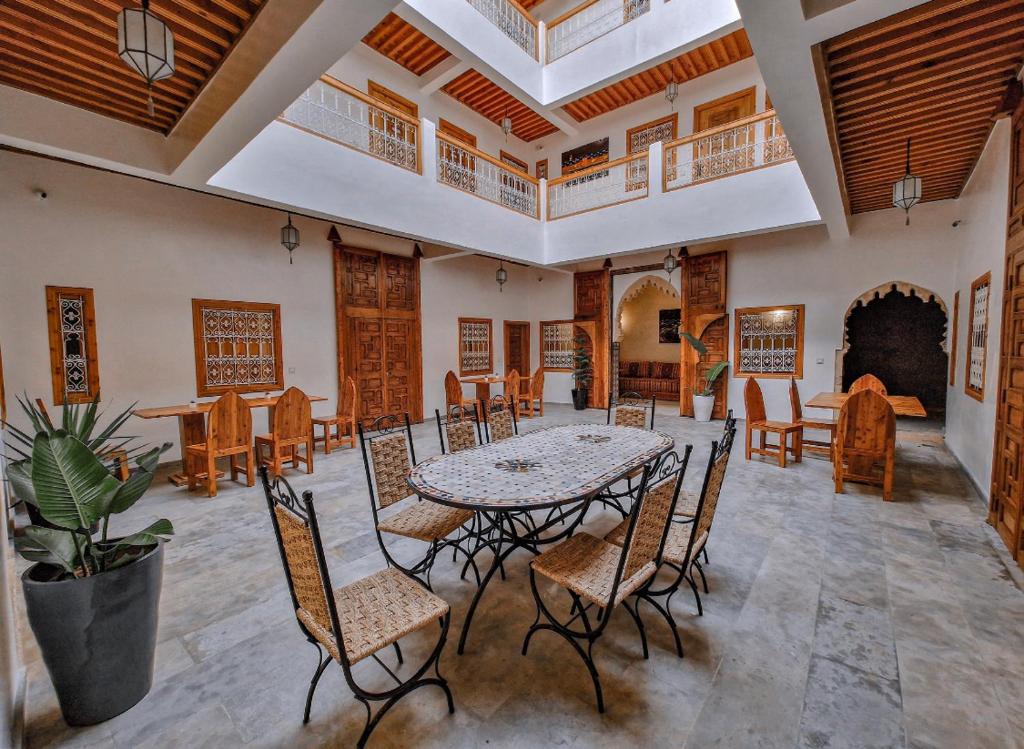 a dining room with a table and chairs and a fireplace at Riad El Pacha in Rabat