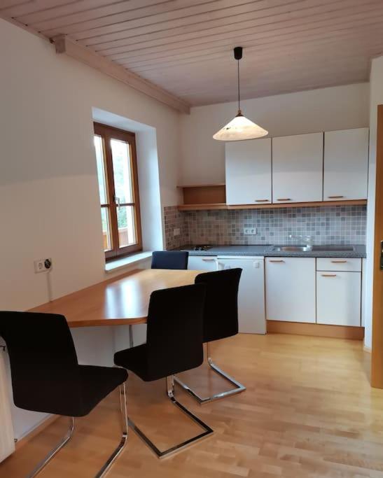 a kitchen with a wooden table and black chairs at Ferienwohnung Bergblick 