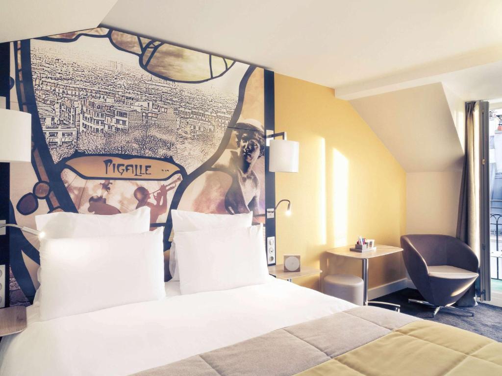 a hotel room with a bed with a poster on the wall at Mercure Paris Pigalle Sacre Coeur in Paris