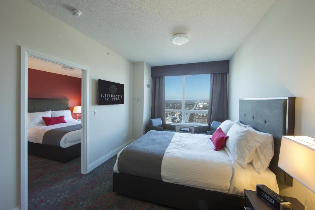 um quarto de hotel com duas camas e uma janela em Liberty Suites em Thornhill