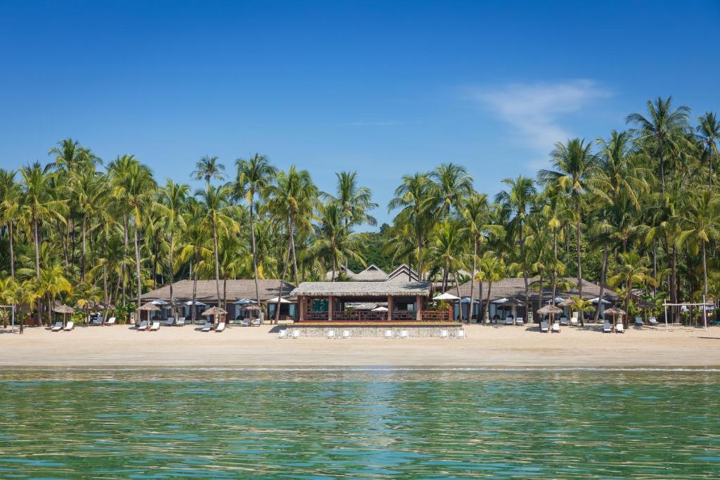 - une plage avec des palmiers et un complexe dans l'établissement Bayview - The Beach Resort, à Ngapali Beach
