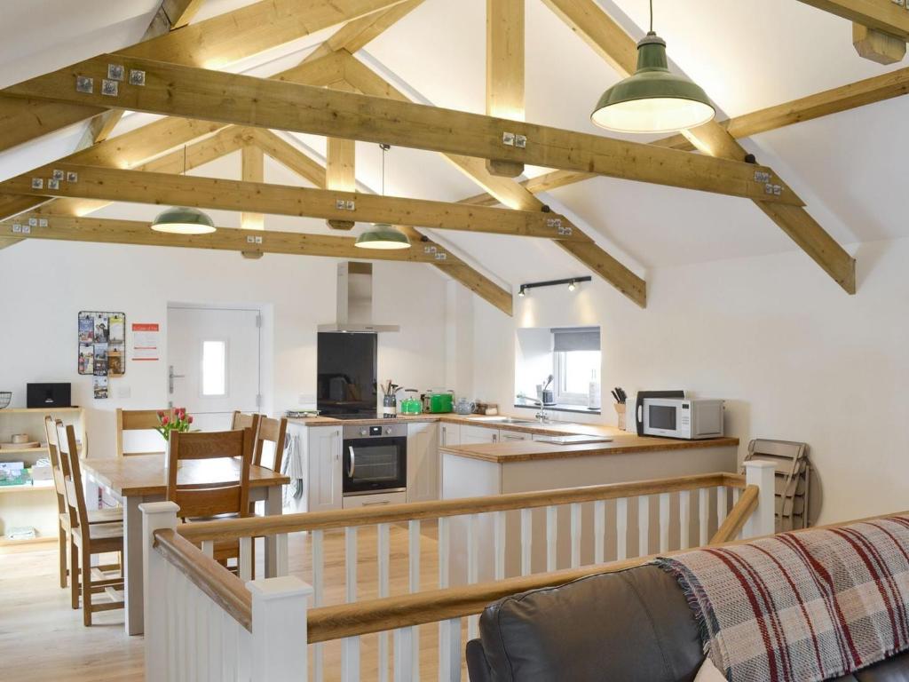 a kitchen and living room with wooden beams at Number Nineteen in Lower Boscaswell