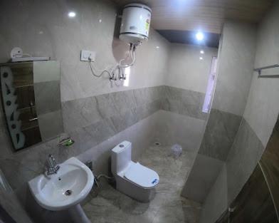 een badkamer met een wastafel en een toilet bij Pinewood kufri in Kūfrī