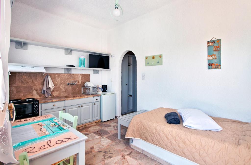 Habitación pequeña con cama y cocina en Apartments with garden view1, en Ierápetra