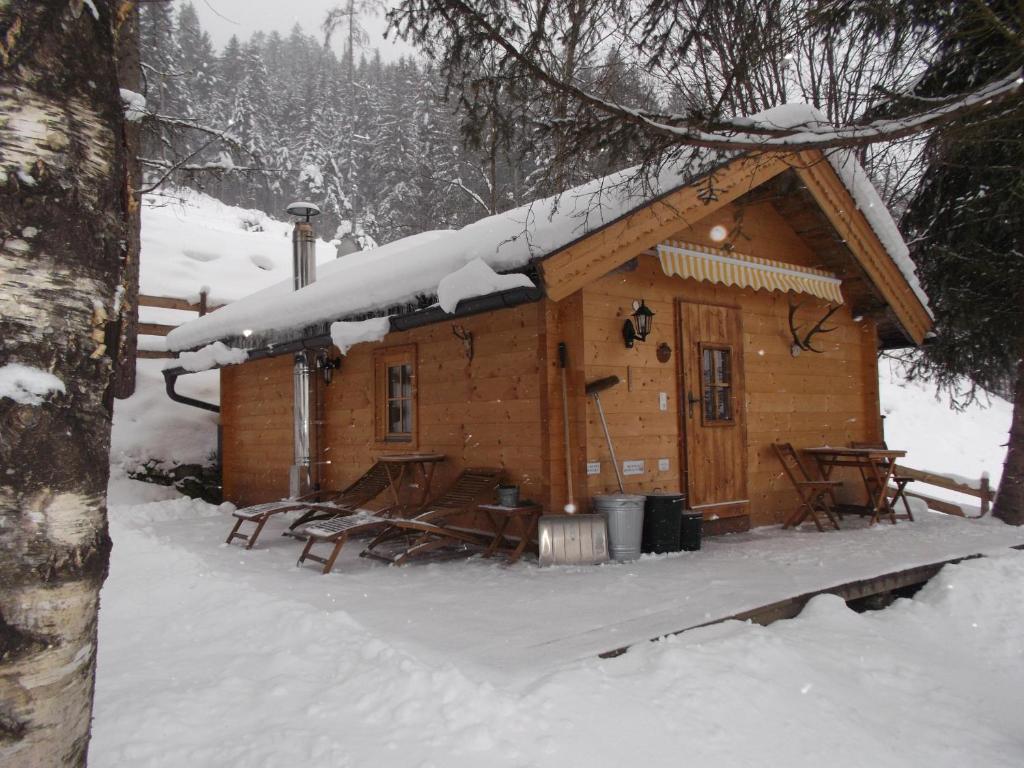 a cabin in the woods with snow on the roof at Sonnhuette in Uttendorf