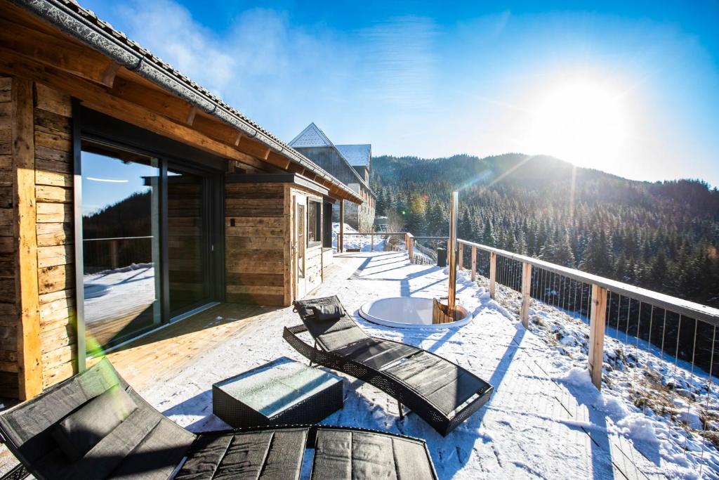 um convés de uma cabana com neve em Seisen Almchalet em Murau