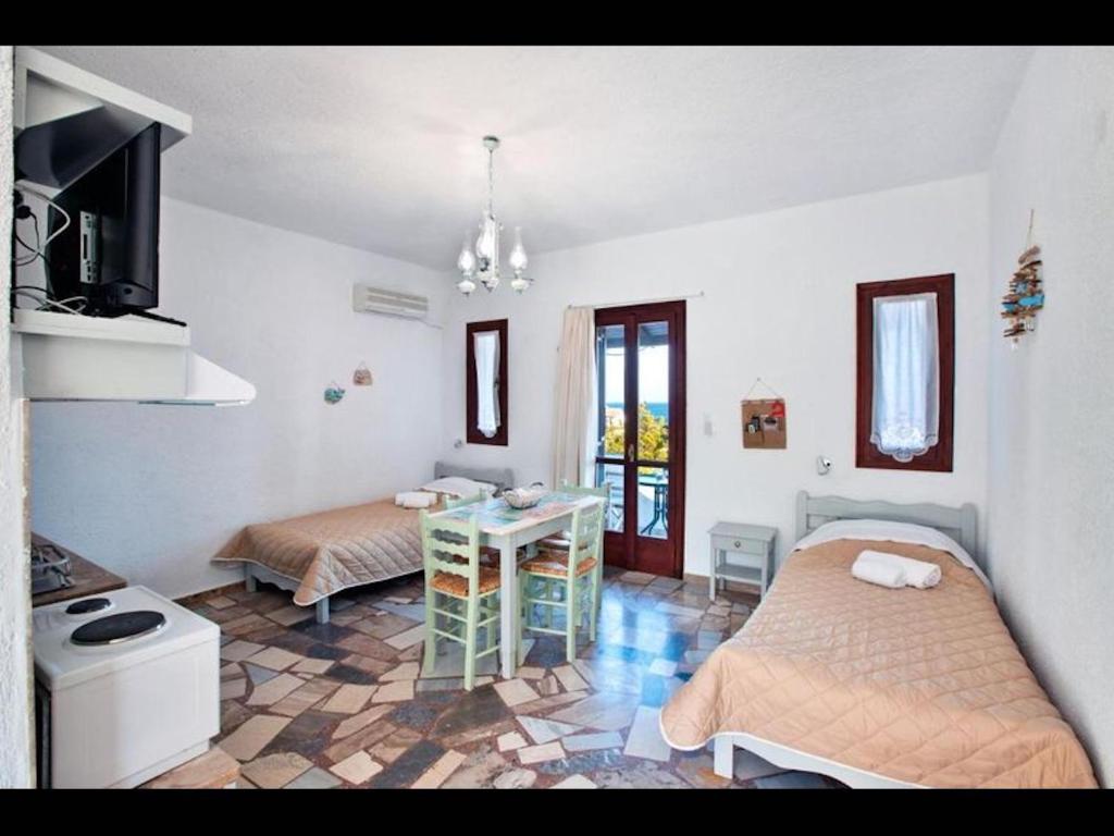 a room with two beds and a table in it at Apartments with sea view1 in Ierapetra