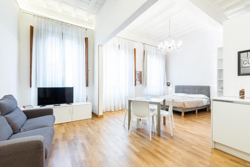een witte woonkamer met een tafel en een bed bij Emanuele's house in Florence