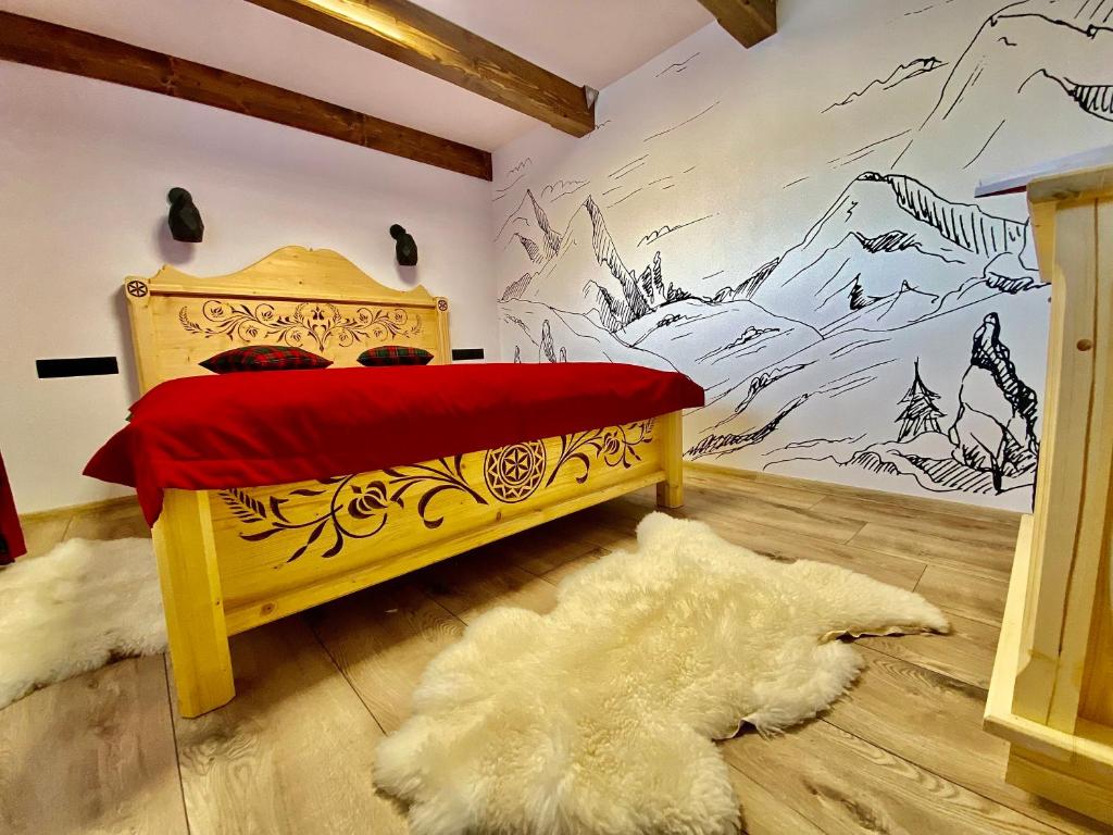 a bedroom with a wooden bed with a painting on the wall at Domek Góralski na Ubocy z jacuzzi in Białka Tatrzańska