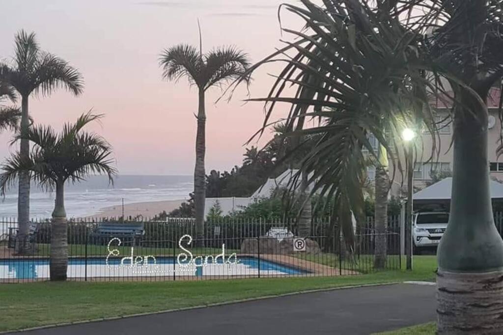 una valla con palmeras junto a una piscina en Beach Holiday Accommodation, en Kingsborough