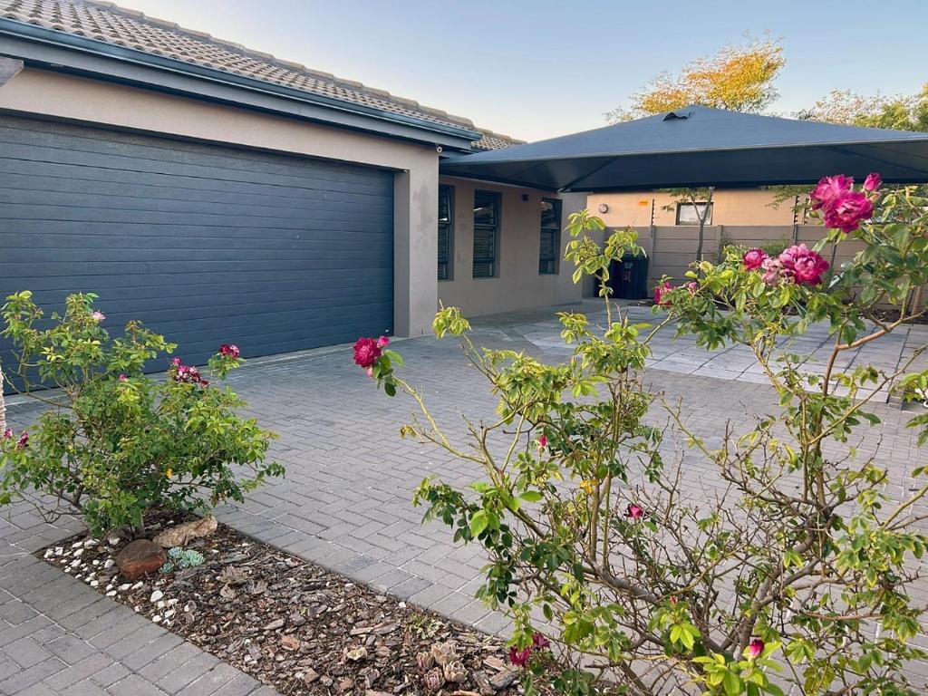 una casa con una porta del garage e dei fiori di 81 on Groenewoud a Città del Capo