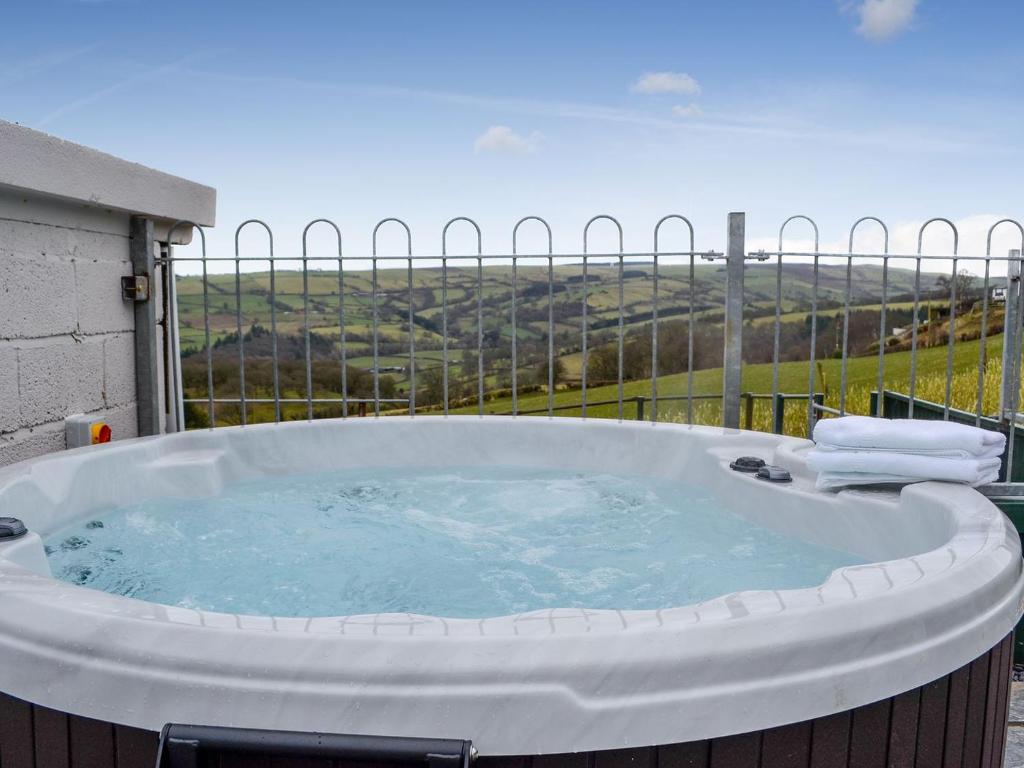 a large hot tub sitting on top of a balcony at Bryn Boda in Nantglyn