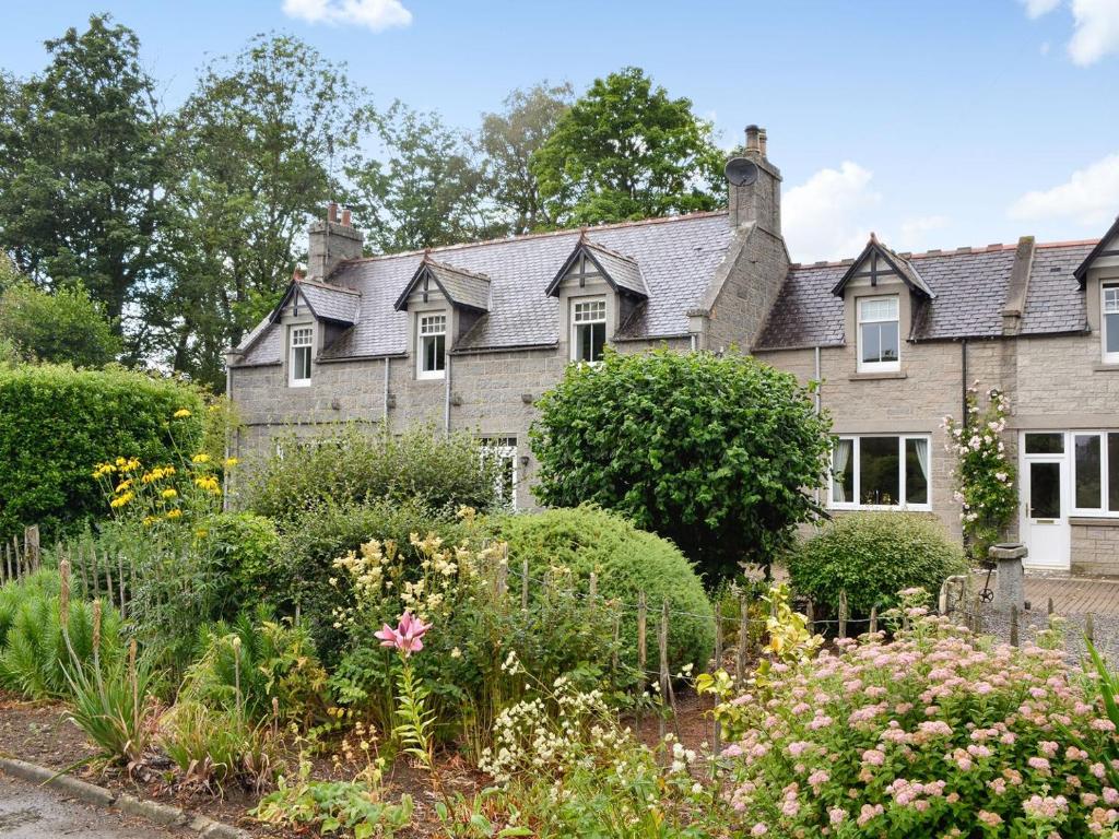 an old house with a garden in front of it at The Coach House in Alford