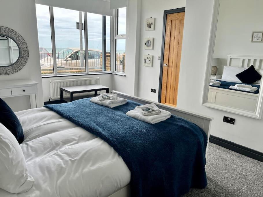 a bedroom with a bed with two towels on it at The Seafront Apartment - Westbrook Bay Beach - By Goldex Coastal Breaks in Kent