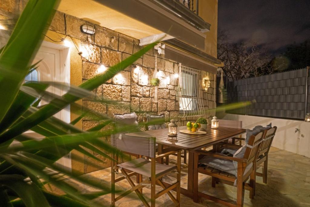 a table and chairs on a patio with a stone wall at Holiday home Ambi for 6, heated pool near Trogir in Trogir