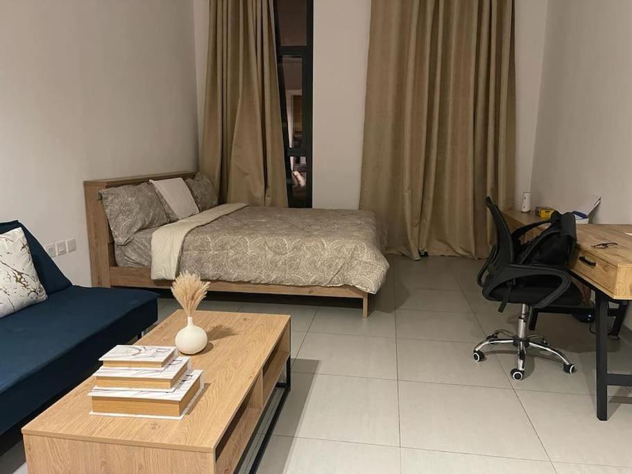 sala de estar con cama y escritorio en luxury 1 BR studio in Sharjah, en Sharjah
