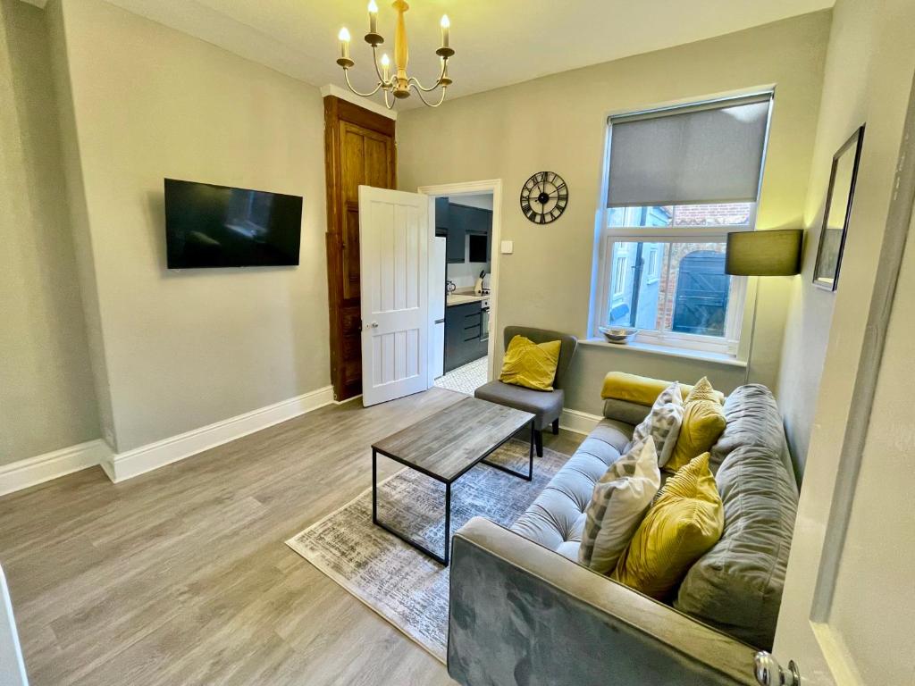 a living room with a couch and a tv at The Balmoral close to the racecourse in York