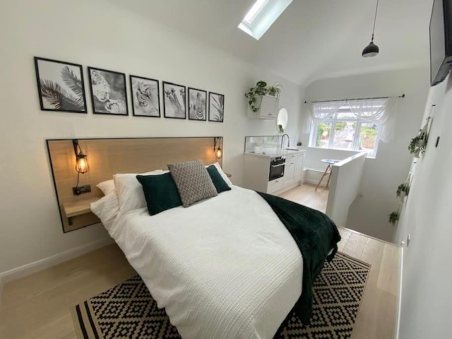 Saltford的住宿－The Annex, Bath Road, Saltford，卧室配有一张带黑色枕头的大型白色床。