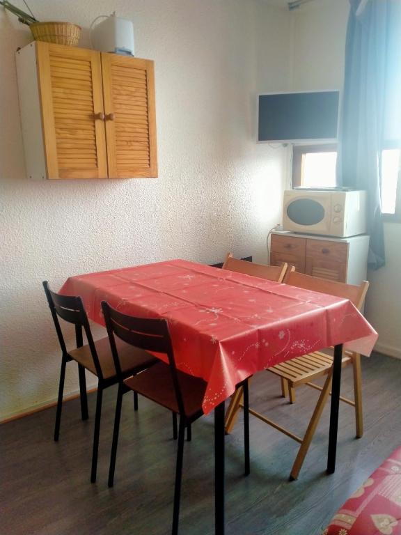 une table avec un chiffon rouge dans la cuisine dans l'établissement Studio Zodiaque, au Corbier