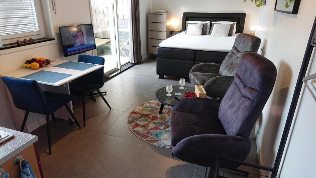 Schlafzimmer mit einem Bett, einem Tisch und Stühlen in der Unterkunft Goody in Zandvoort