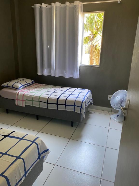 a bedroom with two beds and a window at Ed Bertholi - Frente ao mar com garagem in Serra