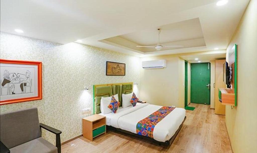 a bedroom with a bed and a chair in it at FabHotel Aerosky Grand in New Delhi