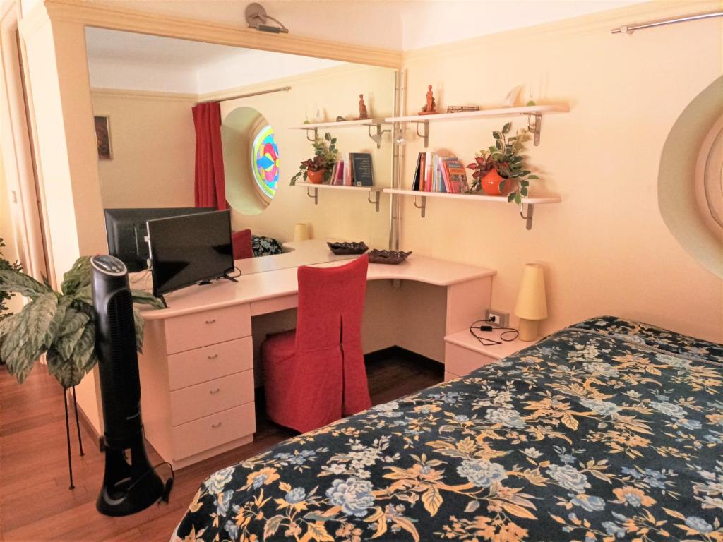 een slaapkamer met een bed en een bureau met een computer bij Casa Alexandra in centro e a pochi passi dal mare in Imperia