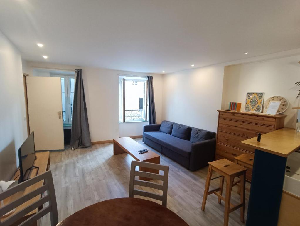 a living room with a blue couch and a table at Tournan en Brie, centre ville, superbe appartement in Tournan-en-Brie