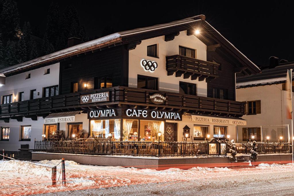 un gran edificio con un restaurante en la nieve en Hotel Olympia, en Lech am Arlberg