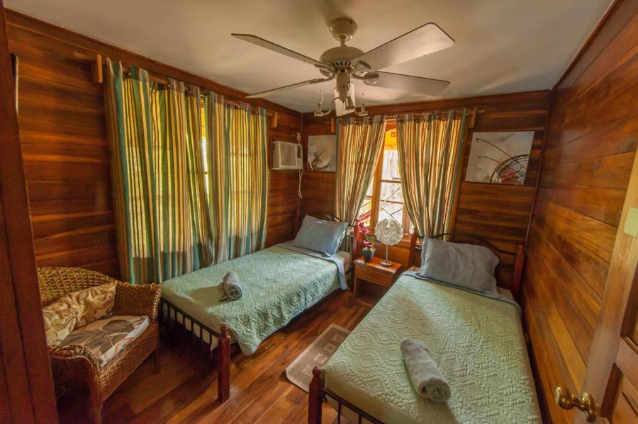 a living room with two beds and a ceiling fan at Tierra Verde Bed & Breakfast in Bocas del Toro