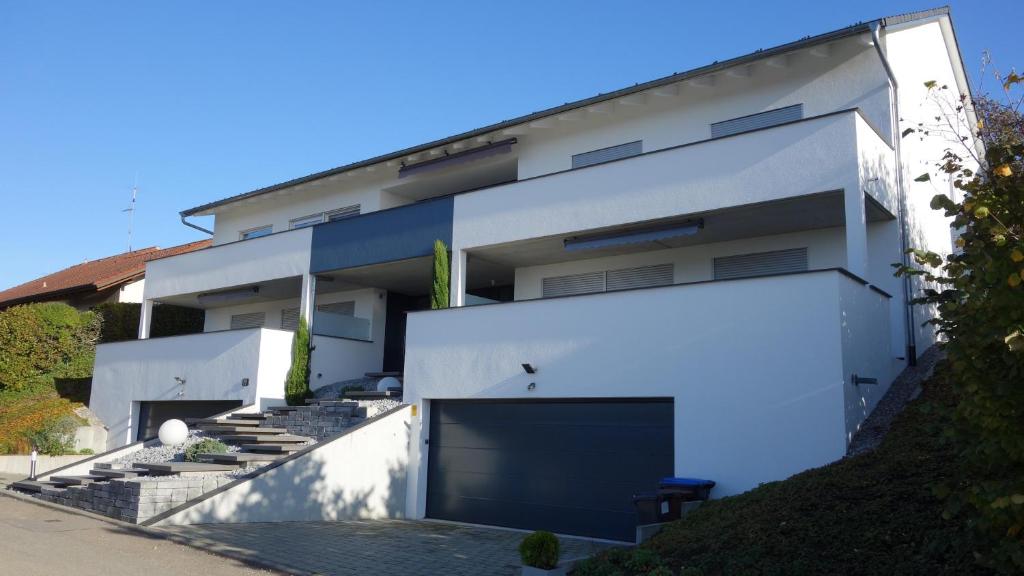 a large white building with a large garage at Birnaublick in Uhldingen-Mühlhofen