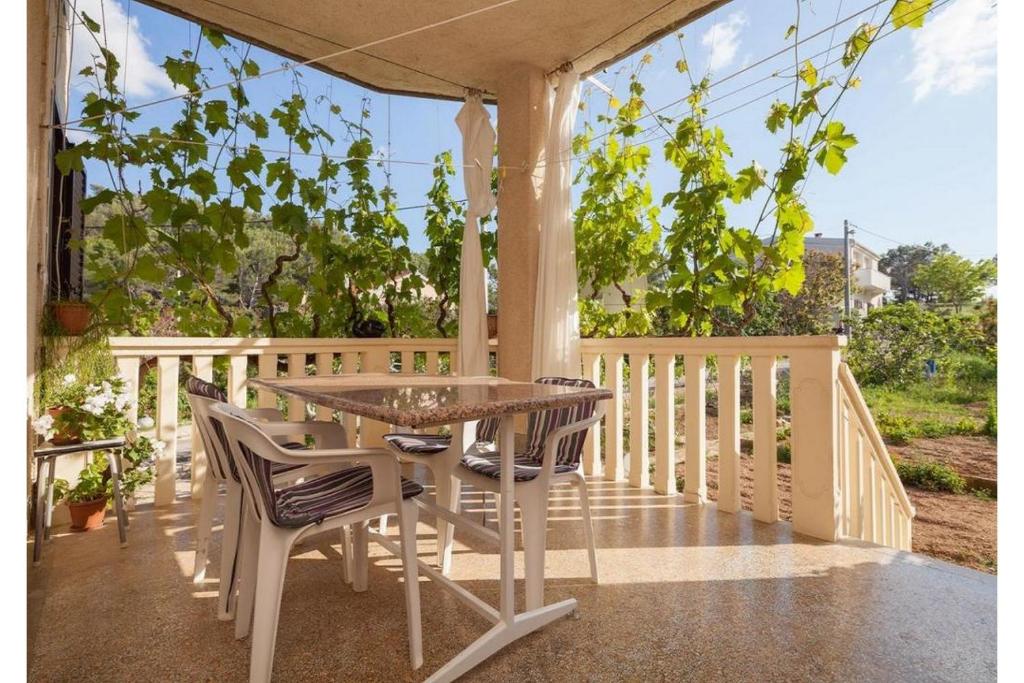 een tafel en stoelen op een veranda met een tuinhuisje bij Apartment Milena in Novigrad Dalmatia