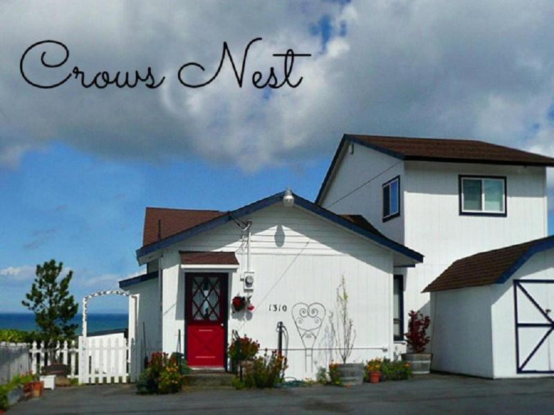 a white house with a red door and the words crazy nest at PA Crows Nest Cottage in Port Angeles