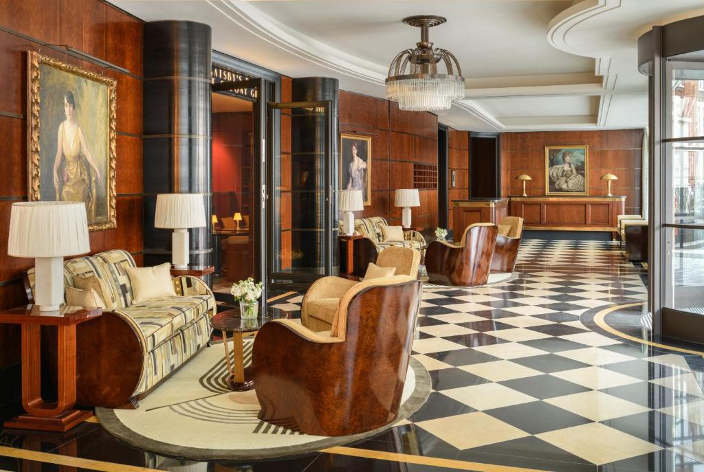 een lobby met banken en een geblokte vloer bij The Beaumont Hotel in Londen
