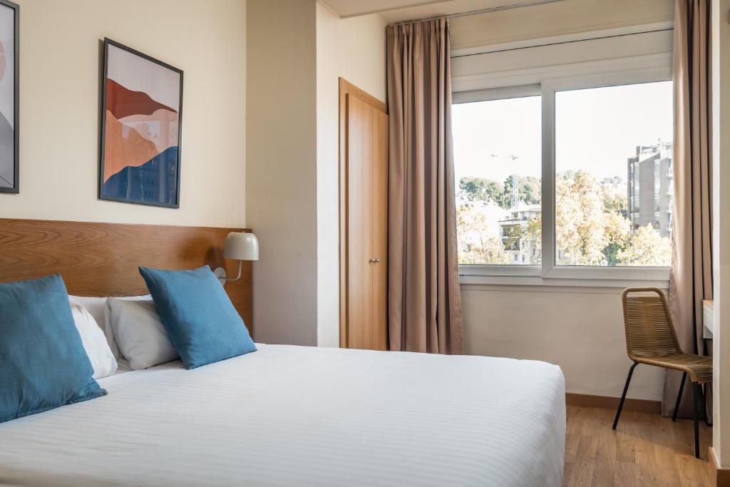 een hotelkamer met een bed en een raam bij BYPILLOW Erba in Girona