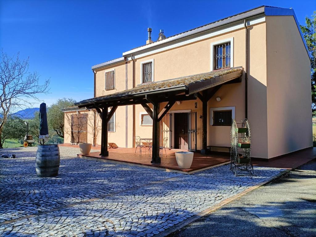 uma grande casa com um alpendre e um pátio em Aromi di casa em Pianella