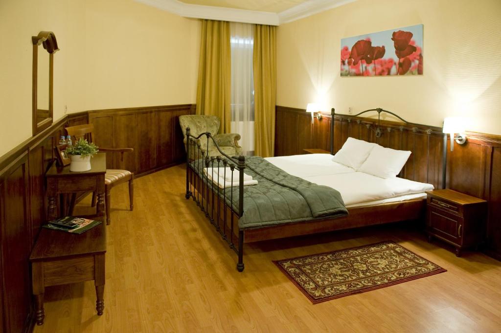 ブィドゴシュチュにあるHotel Kresowiankaのベッドルーム1室(ベッド1台、椅子、テーブル付)