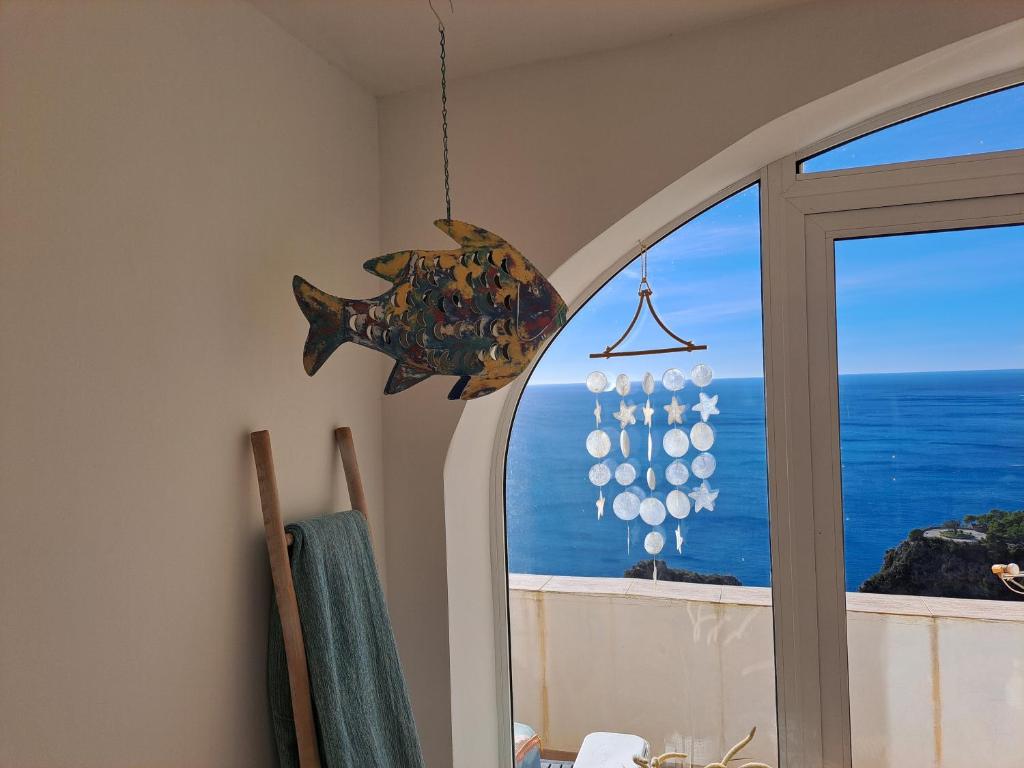 a fish chandelier in a room with a window at la ventana al mar in Jávea