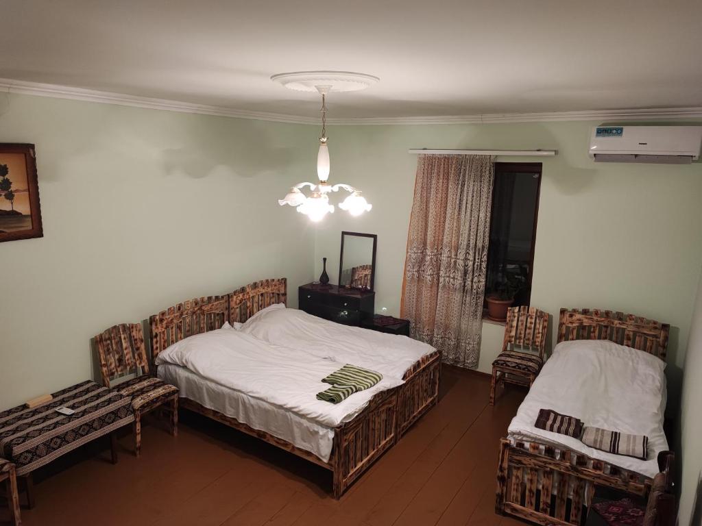 a bedroom with two beds and a chandelier at Berdavan Guesthouse in Berdavan