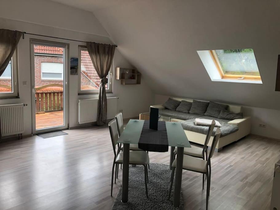 sala de estar con mesa, sillas y sofá en Ferienwohnung an der Nordsee en Sande